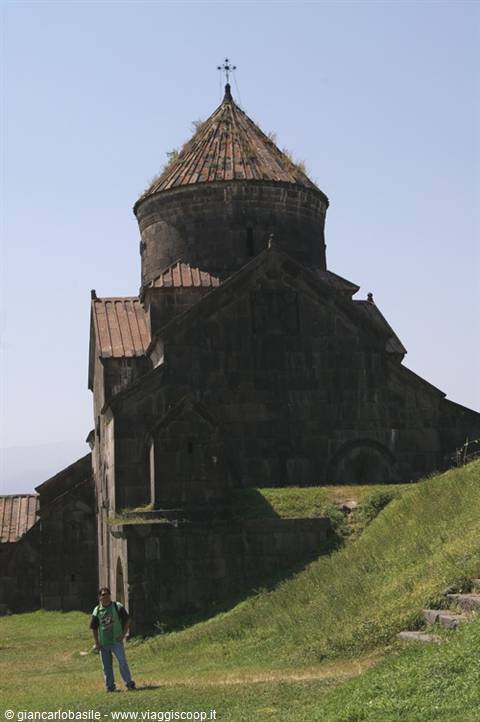 Tourist beside the dark medieval stone church of Haghpat monastery