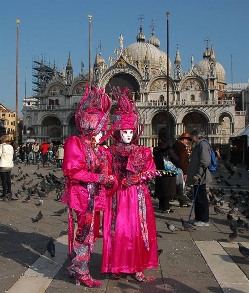 Two pink carnival masks in front of St Mark's Basilica, Venice