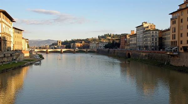 The Arno in Florence with Ponte alla Carraia and sunlit historic buildings