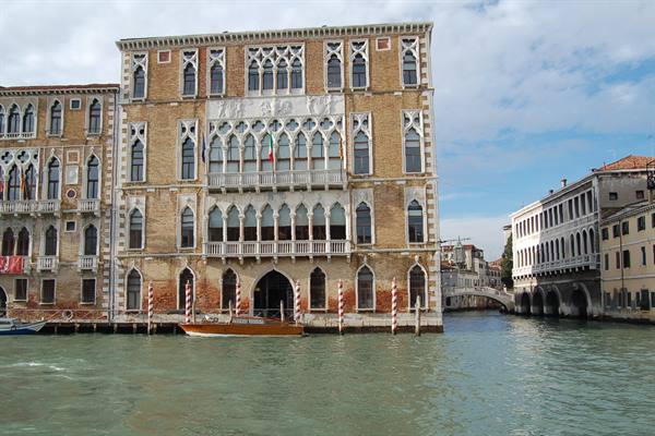 Ca' Foscari on Grand Canal, gothic brick facade, wooden pole and boat
