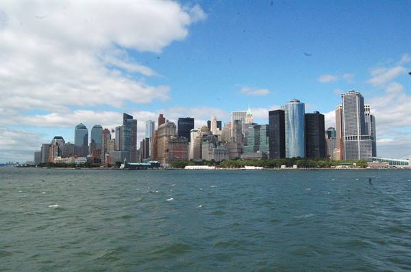 Manhattan skyscrapers seen from the water under a cloudy sky