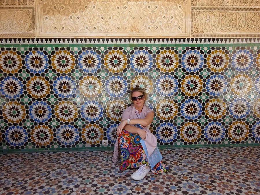 Donna seduta davanti a un mosaico di zellige del mausoleo di Moulay Ismail, Meknes