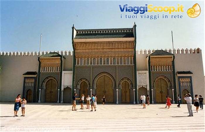 Ornate gate of Fez royal palace, tiled mosaics and painted wood under sun