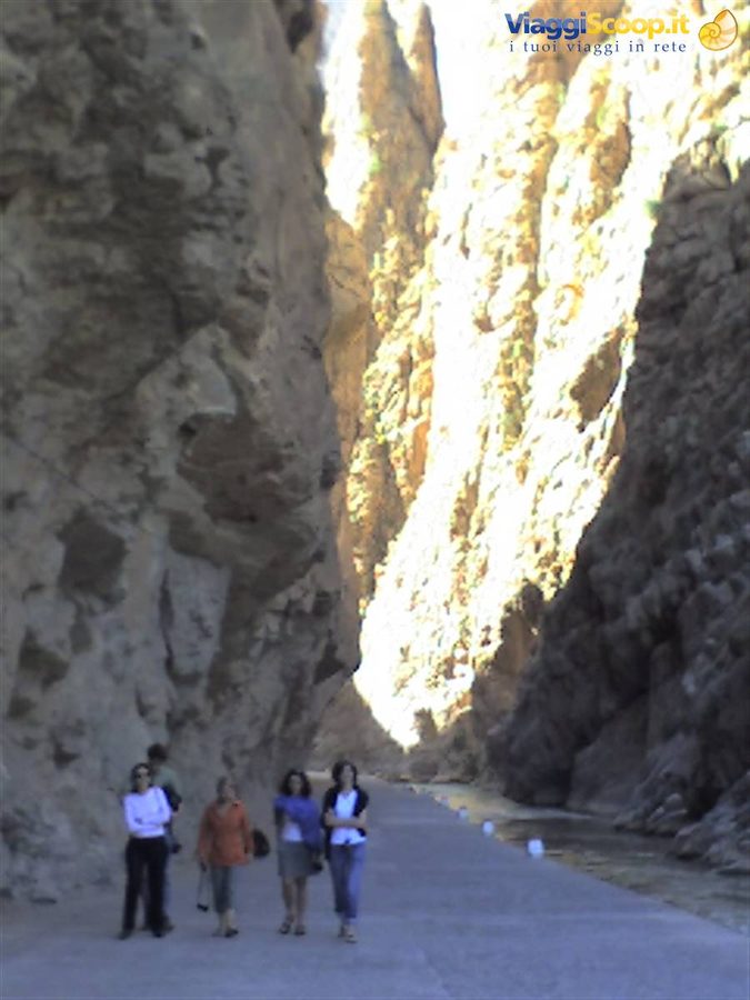 Women walking on the narrow road between the towering rock walls of Todra Gorge