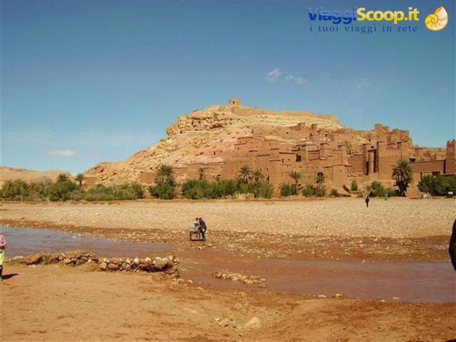 Aït Benhaddou, mud-brick kasbah above the river, tourists crossing the ford